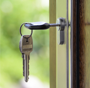 A set of keys hanging in a door lock to represent Security